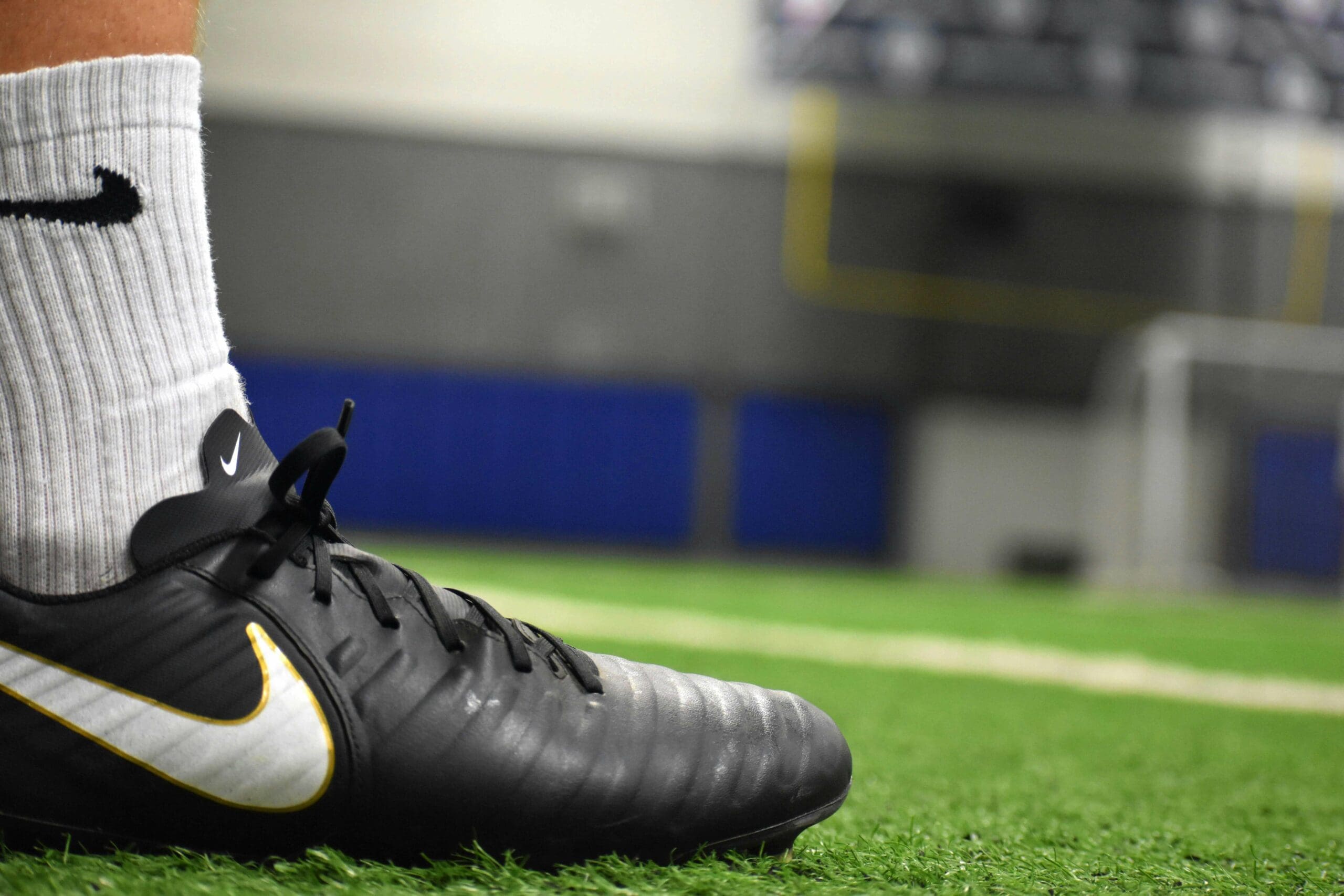 Joueur de football portant des chaussures adaptées sur terrain synthétique